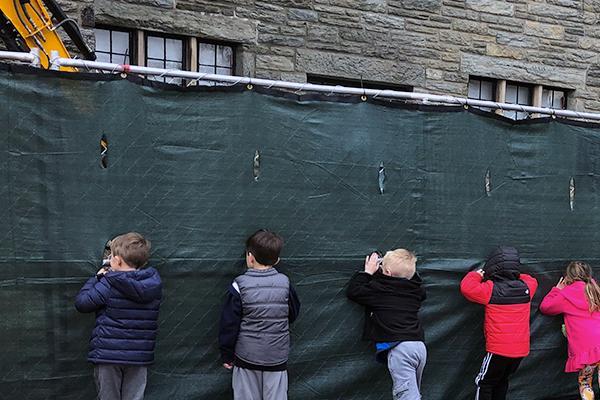 Children peering through to the construction zone.